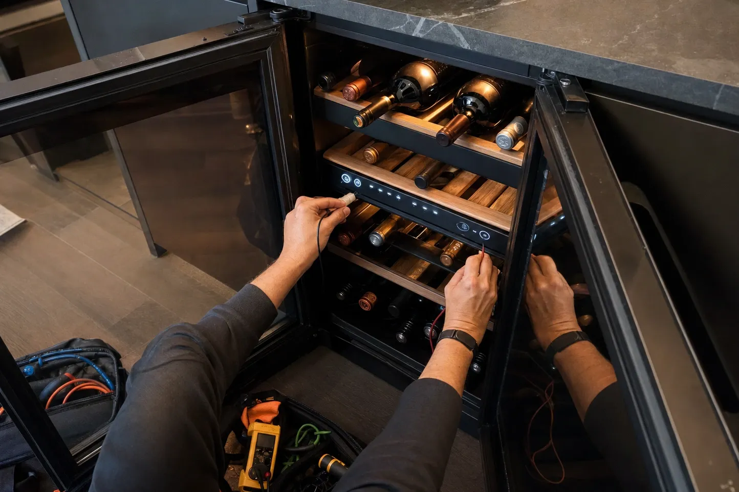 Overhead view of an open wine unit with bottles on wooden racks, a lit control strip across the middle shelf and a thermometer lead held to it